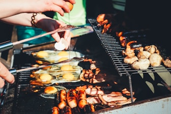 person holding tong with grilled food