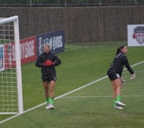 A footballer training intensely under the rain.