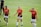 Three female soccer players walk across a grassy field wearing orange and black team jerseys with the logo 'DASH' and sponsor 'BBVA Compass'. They appear to be focused, possibly after a training session or match.