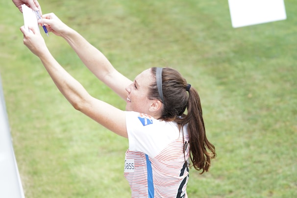 Young athlete signing scholarship papers with coach by her side