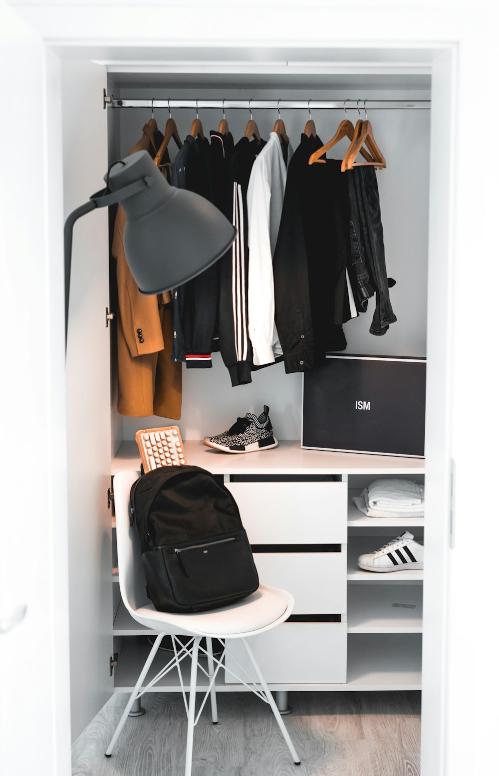 black backpack on white chair beside cabinet