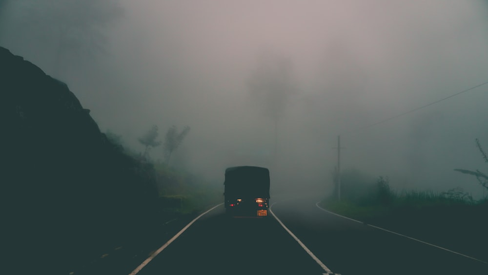 black vehicle in foggy road