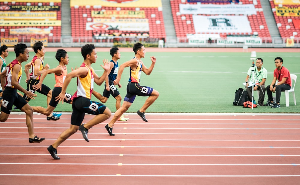 陸上競技場を走る男性のグループ