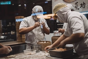 A cheerful chef preparing perogies in a bustling kitchen.