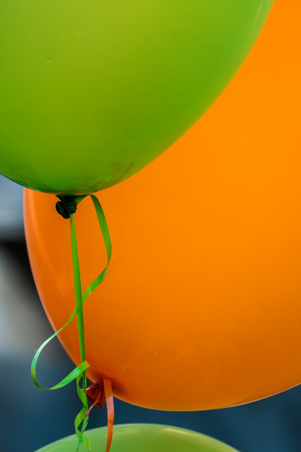 shallow focus photography of green and orange balloon