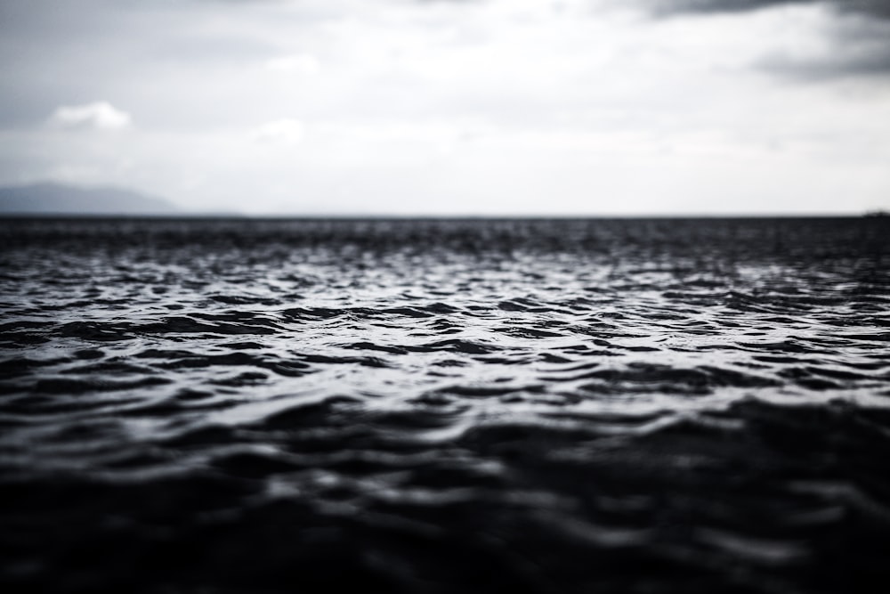 grayscale photography of rippling body of water
