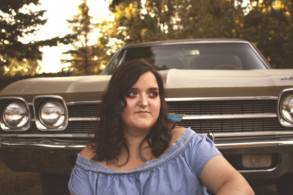 woman sitting near brown classic car