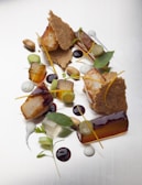 Elegant plating of seared scallops with a delicate sauce drizzled in a modern style.