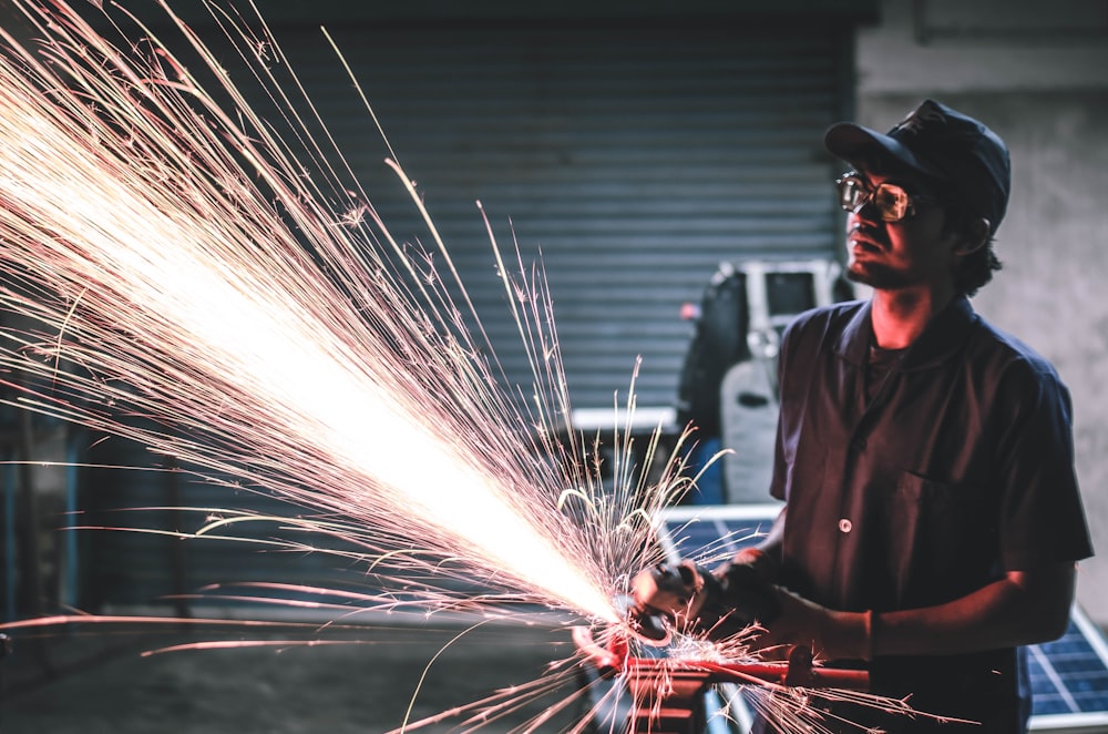 man in brown button-up shirt grinding metal