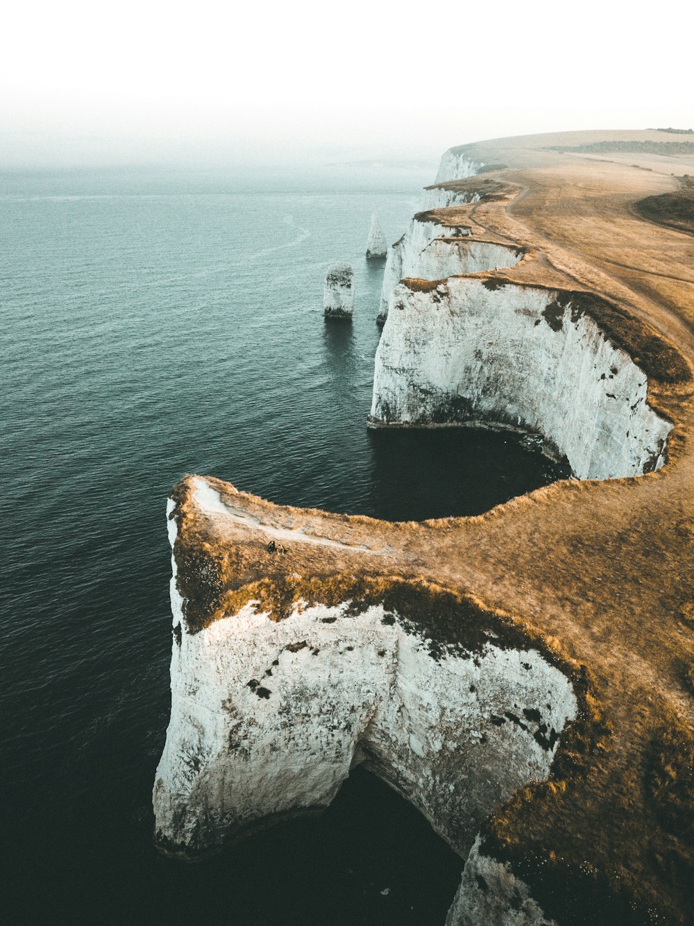 aerial view photography of mountain cliff near body of water at daytime