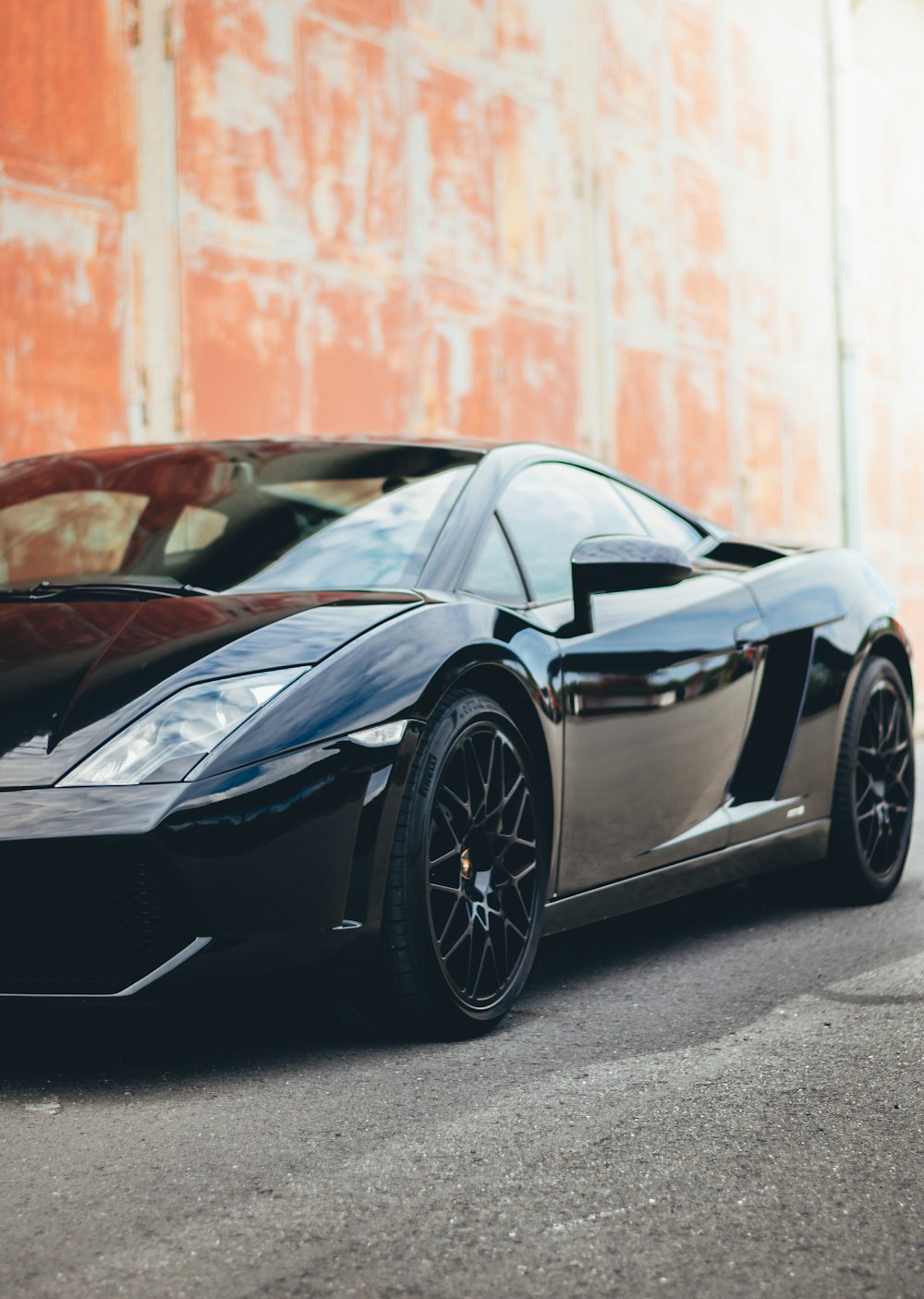 black supercar parked near orange wall