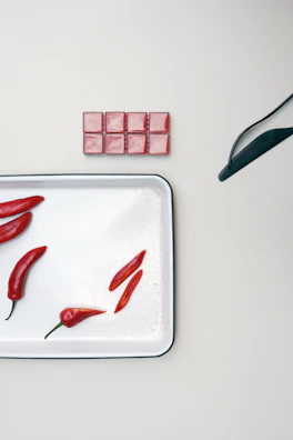 An elegant butter piece with chili pepper accents displayed on a sleek white surface.