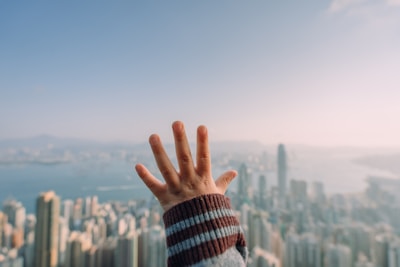 Hands exchanging a parcel with a city skyline in the background.