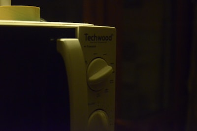 Close-up of a repaired microwave oven with a satisfied customer in the background.