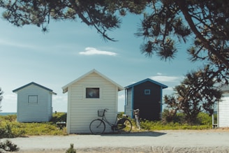 black city bicycle park beside white wooden house