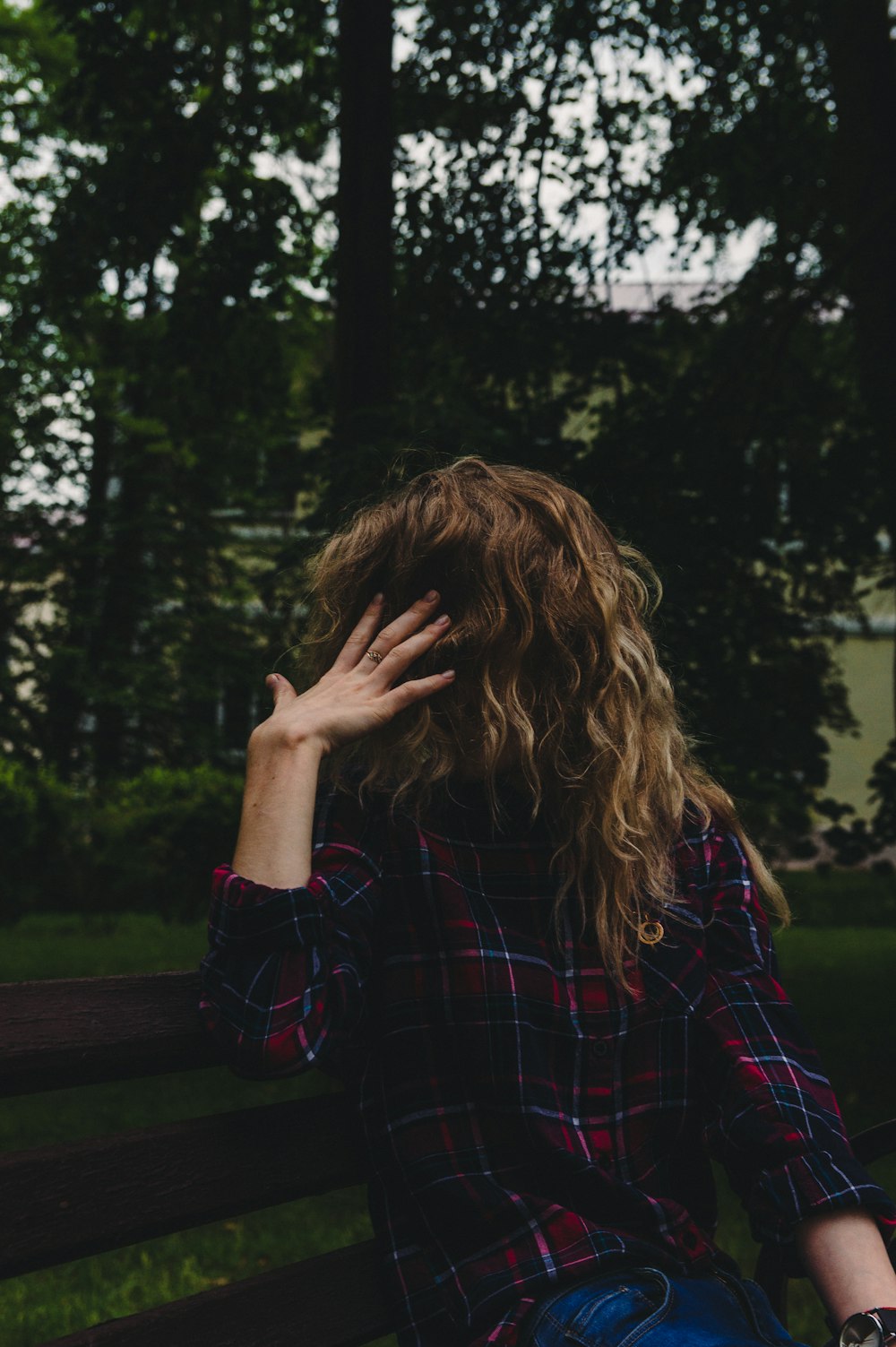 woman sitting on brown wooden bench