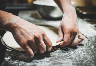 a person is kneading dough on a table