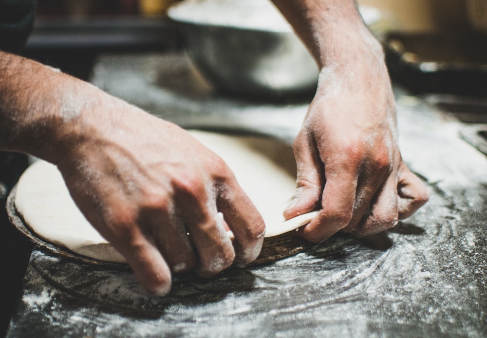 a person is kneading dough on a table