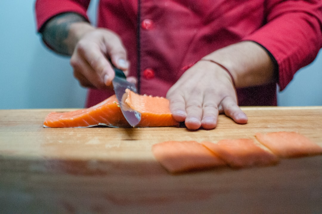 person slicing salmon, slicing the salmon