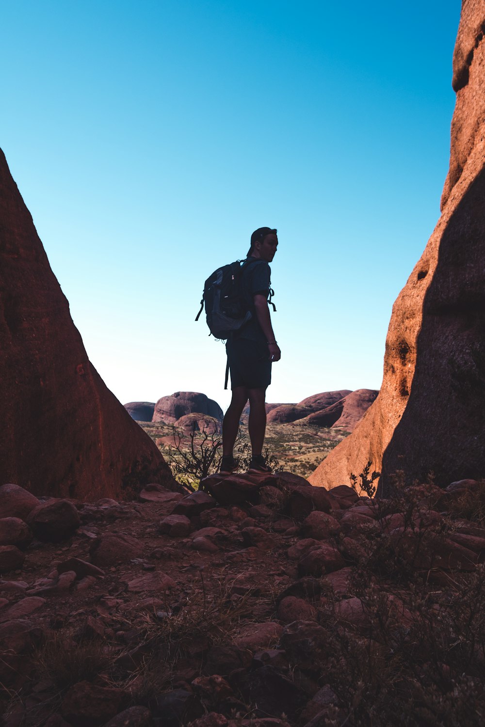 a man with a backpack standing on a rocky outcropping