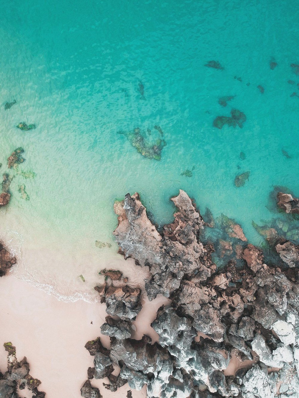 bird's eye view photography body of water crashing on rocks