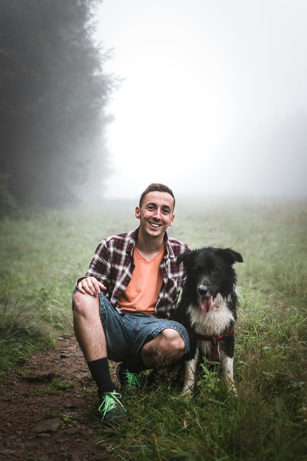 homme assis à côté d’un chien noir