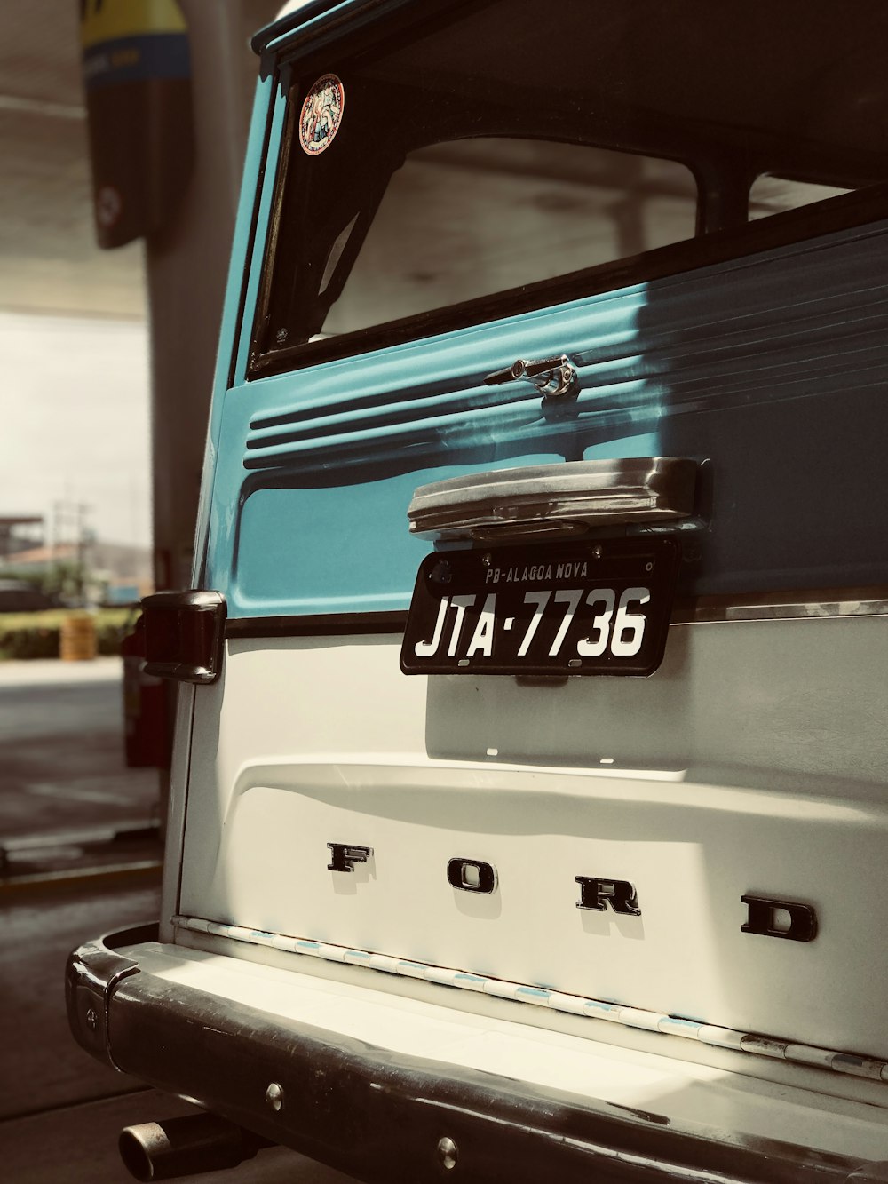 white and teal Ford vehicle at daytime