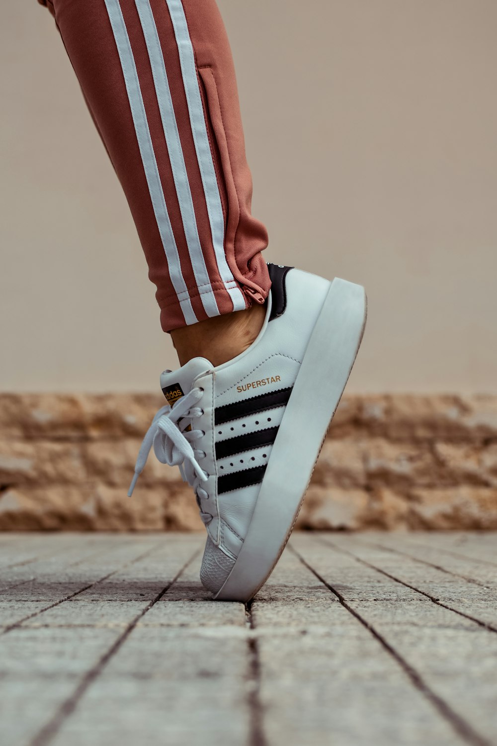 person wearing white and black adidas Superstar sneaker