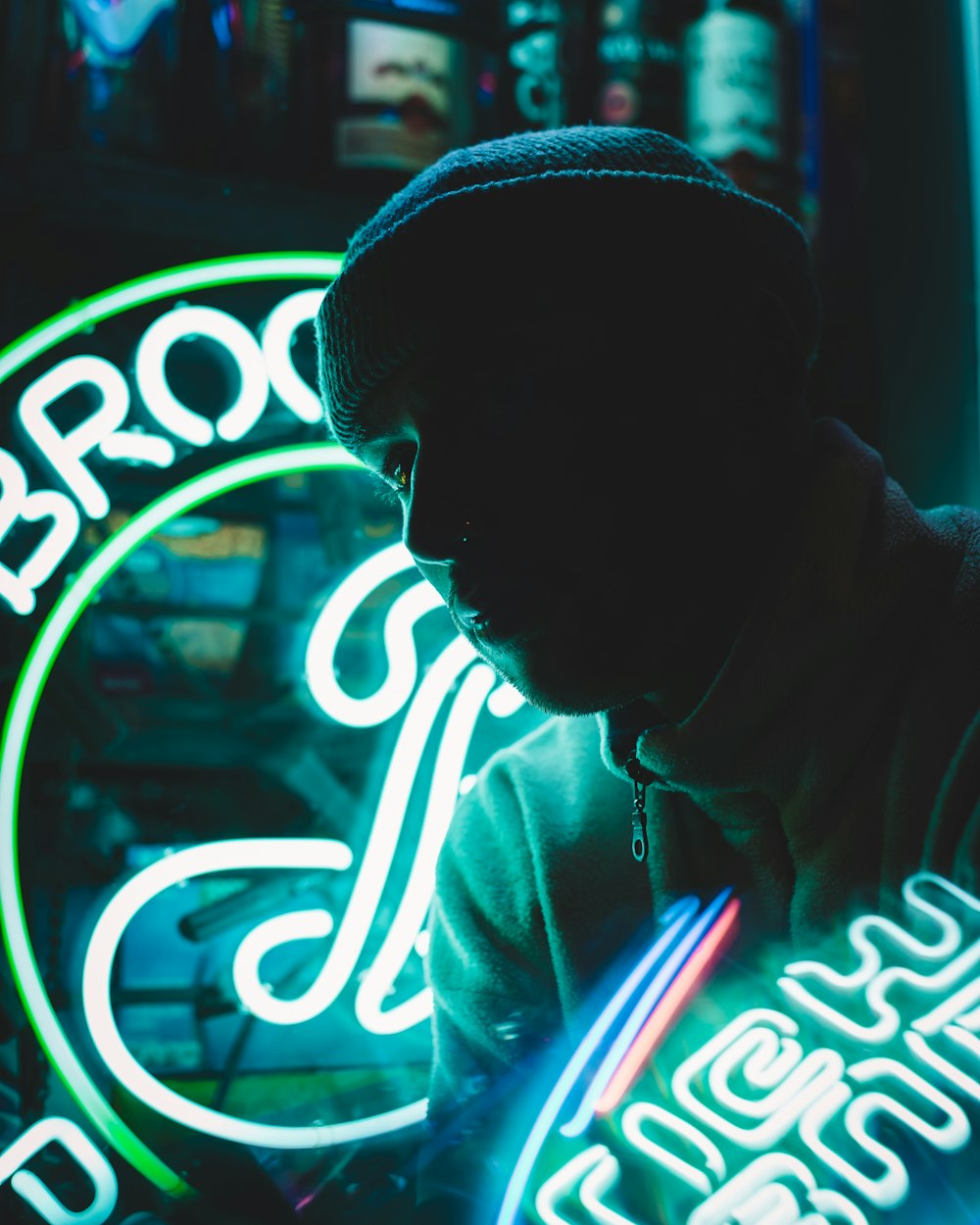 a man standing in front of a neon sign