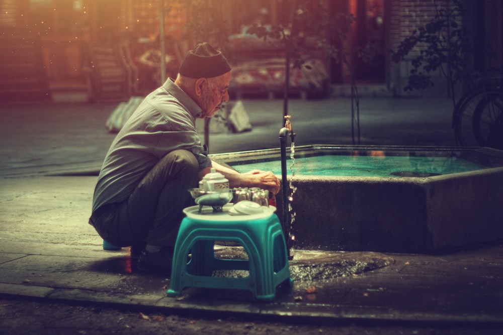 person sitting beside plastic stool