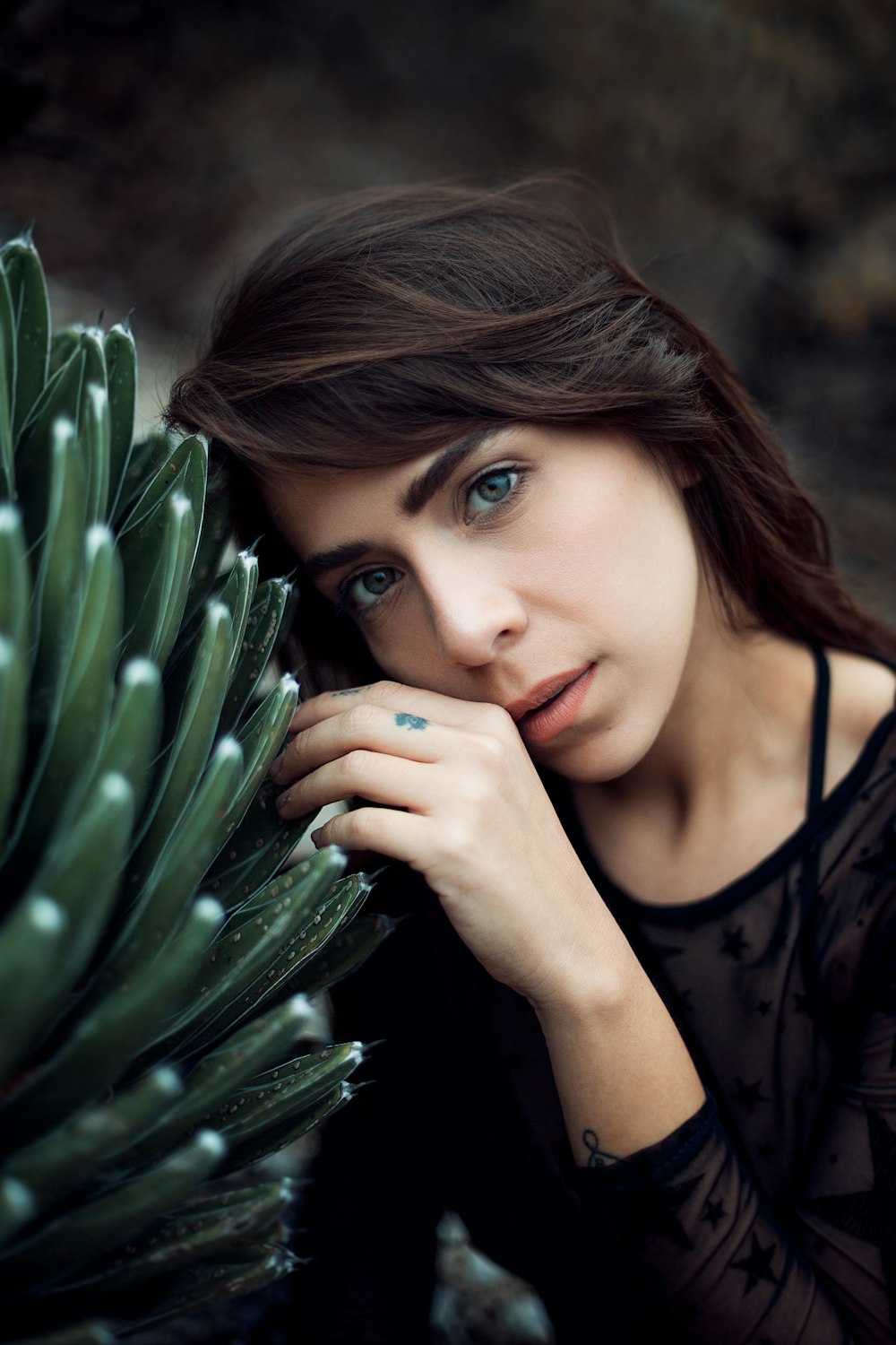 woman leaning on green plant