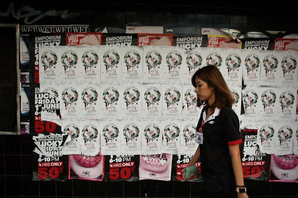 man walking beside white and black wall