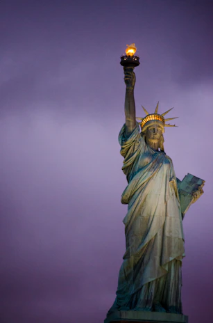 A glowing torch held high against a twilight sky symbolizing hope and knowledge.