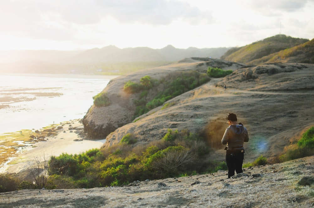 photo of man standing on mountain