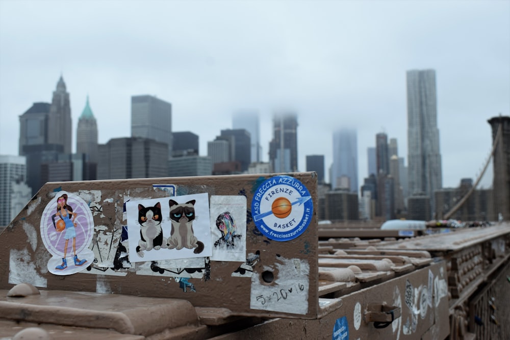 a street sign with stickers on it in front of a city skyline