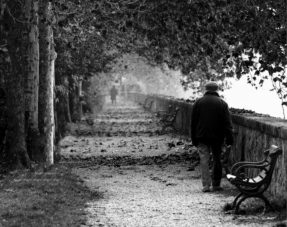 grayscale photography of person walking on street