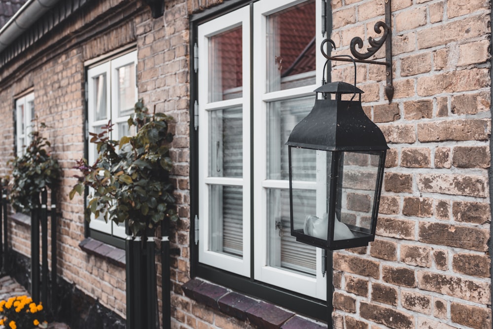 black outdoor sconce light on brown brick wall