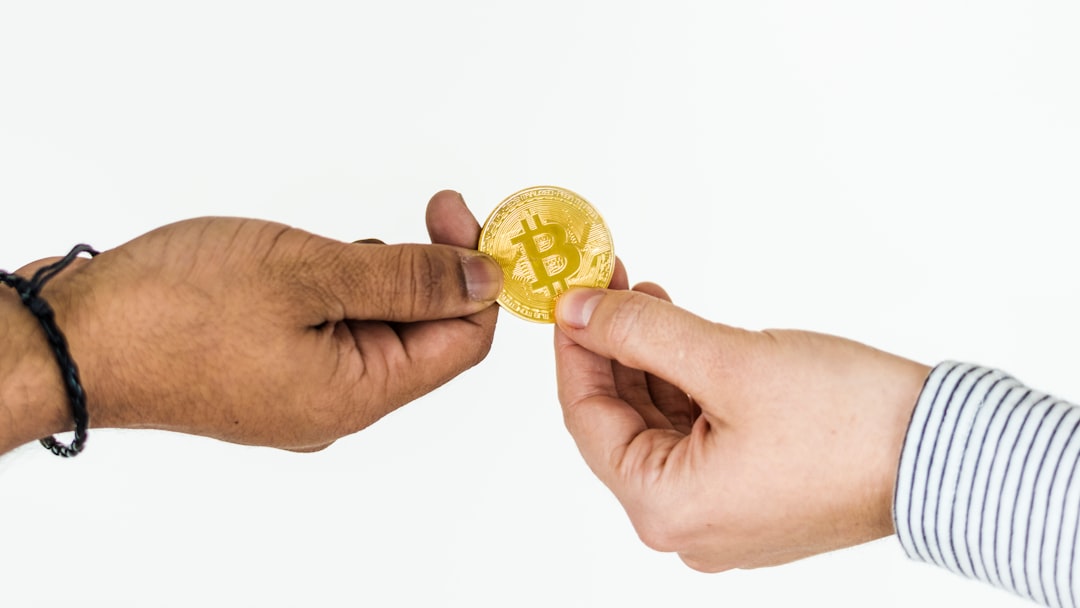 two persons holding gold-colored Bitcoin