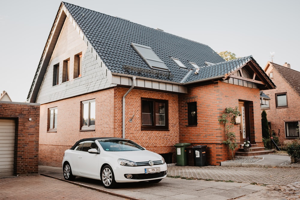 white Volkswagen Jetta parked beside house