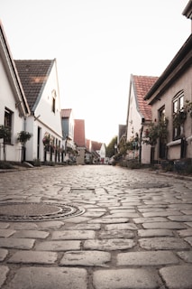 A narrow cobbled street lined with colorful terraced houses under a soft morning light.