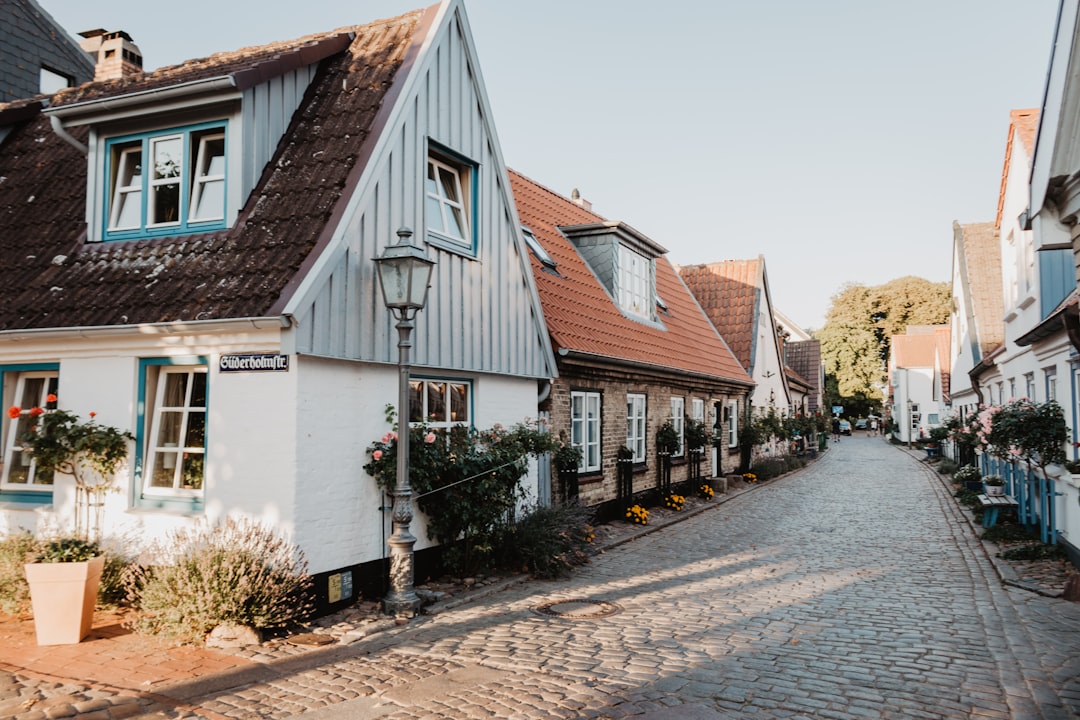 white and brown concrete house, road in Schleswig Germany with lots of houses