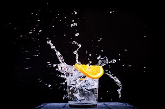 splash of water in drinking glass with sliced lemon