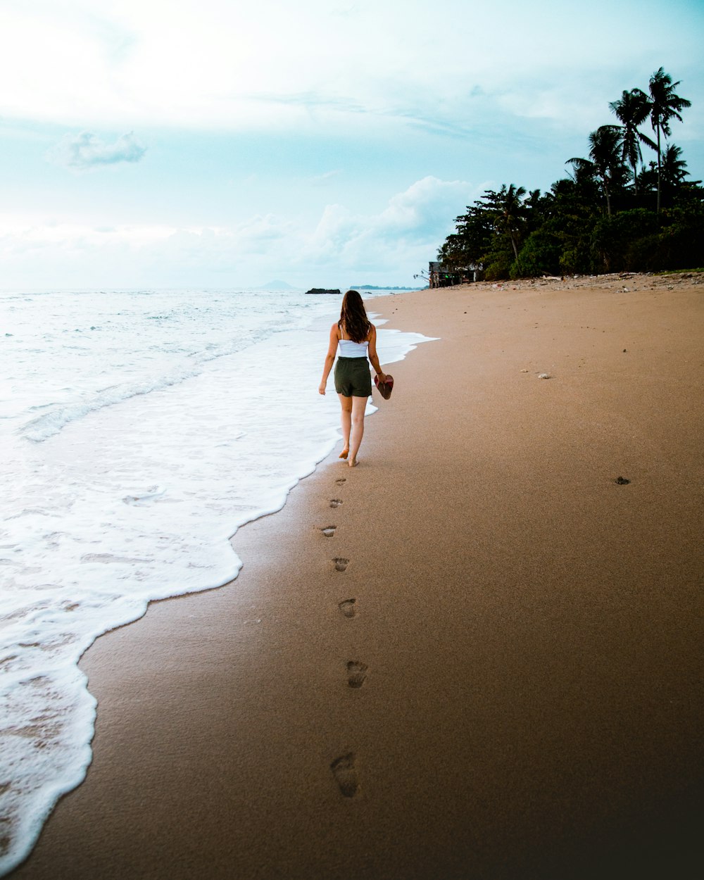 Mujer caminando frente a la playa