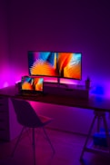 turned on flat screen monitor and black laptop computer on table