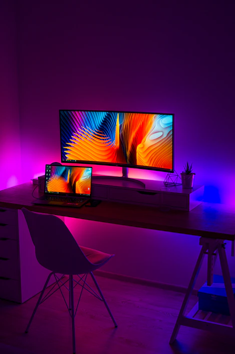 A sleek modern gadget setup on a desk with soft glowing lights and minimalistic decor around.
