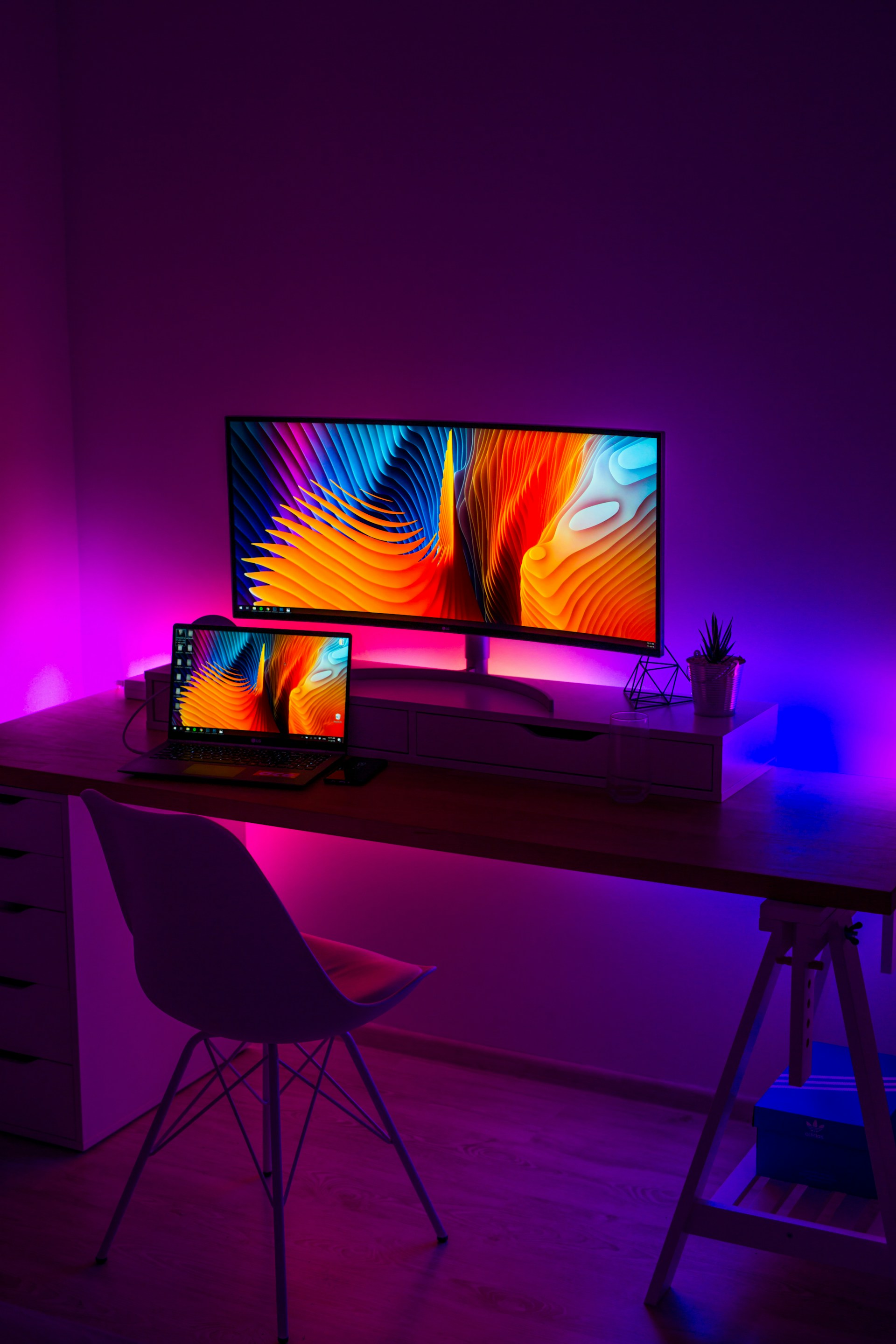 turned on flat screen monitor and black laptop computer on table