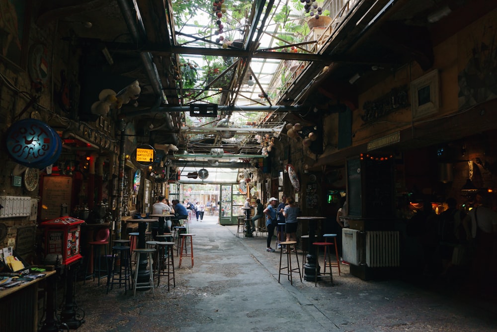 a narrow alley way with lots of tables and chairs