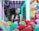 A woman is standing inside a brightly lit claw machine surrounded by colorful plush toys. She is looking directly at the camera with a thoughtful expression. The claw is suspended above the pile of toys, and the background is illuminated with neon lights.