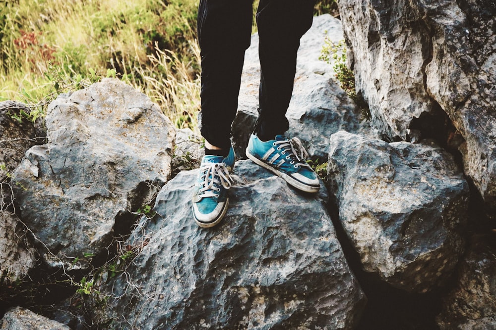 person wearing teal adidas low-top sneakers