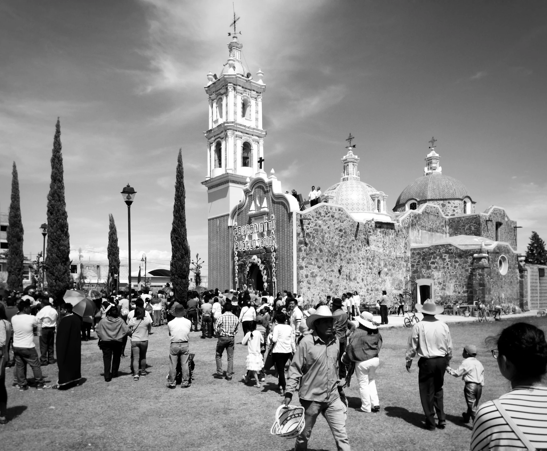 A warm, nostalgic black-and-white photo of church members gathered for a joyful celebration in the 1970s.